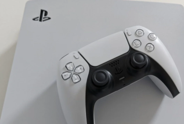 Pad do PlayStation 5 leżący na konsoli.