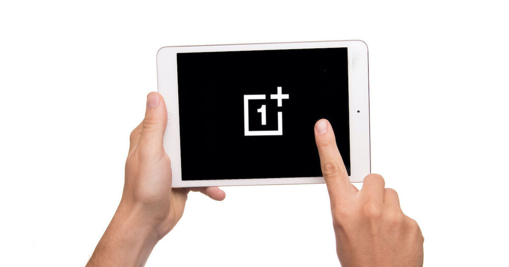 Dłonie trzymające tablet z logiem OnePlusa