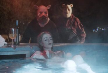 Kadr z horroru Winnie the Pooh: Blood and Honey z dziewczyną w jacuzzi, za którą stoją Puchatek i Prosiaczek