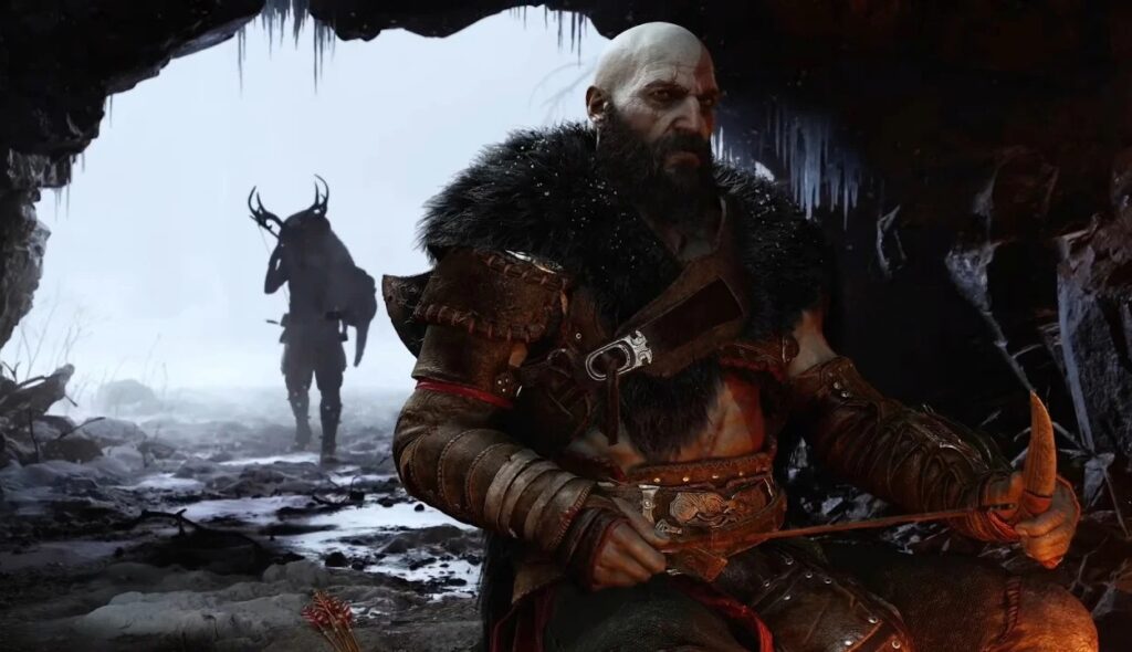 Kratos z futrem na ramionach siedzący w jaskini