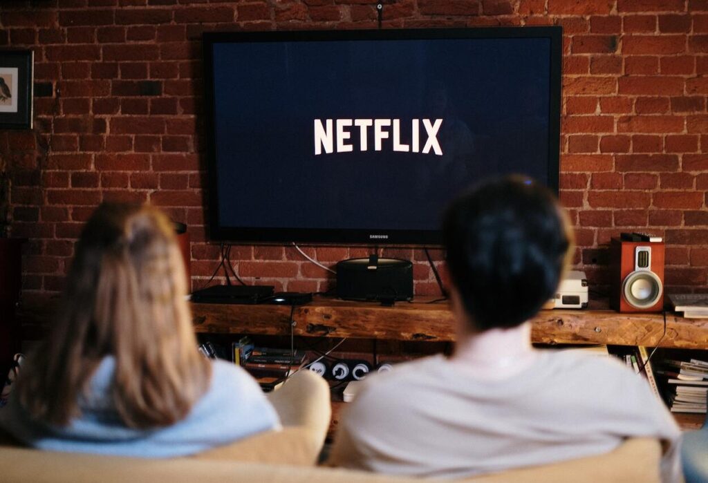 Mężczyzna i kobieta oglądają Netflixa na telewizorze.