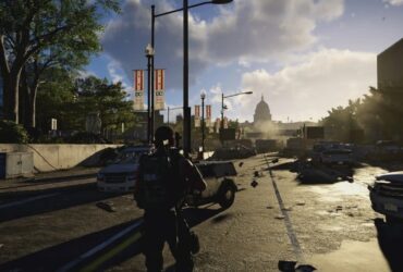 Postać z gry The Division 2 idąca przez miasto z pełnym wyposażeniem i bronią w rękach.