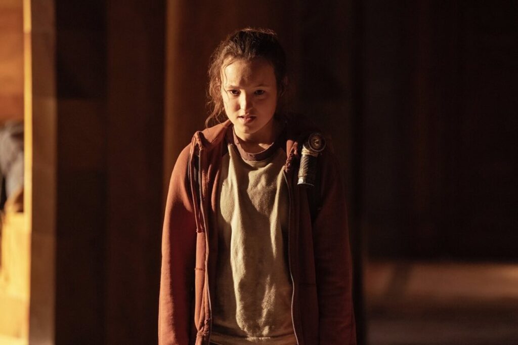 Oświetlona Ellie w budynku w serialu The Last of Us