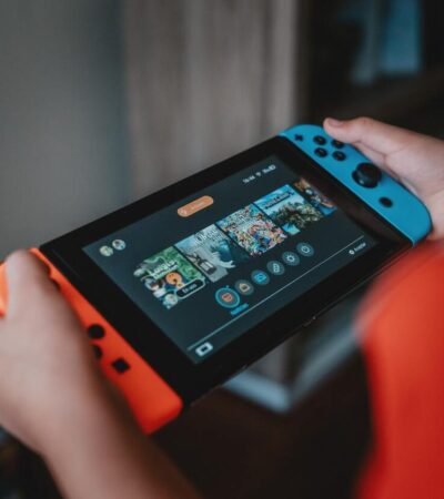 Gracz korzystający z konsoli Nintendo Switch w trybie handheld