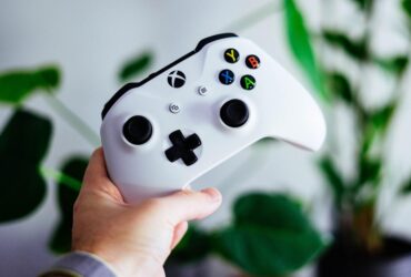 Gracz trzymający biały kontroler od Xboxa Series X