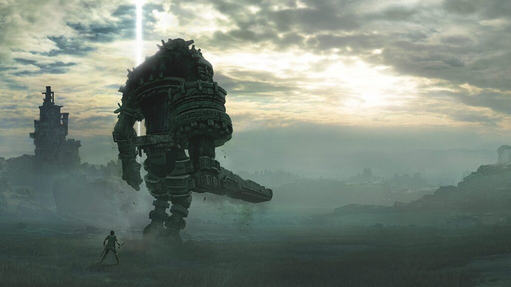 Główny bohater Shadow of the Colossus z mieczem obok jednego z kolosów w grze