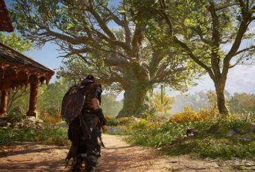 Eivor stojący przed dużym rozłożystym drzewem w Assassin's Creed Valhalla