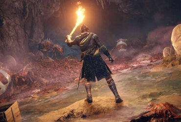 Gracz Elden Ring przemierzający jaskinię z pochodnią w ręku