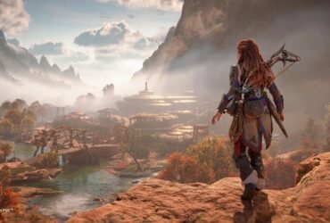 Alloy stojąca na wzgórzu przed zamglonym widokiem na wioskę w Horizon Forbidden West