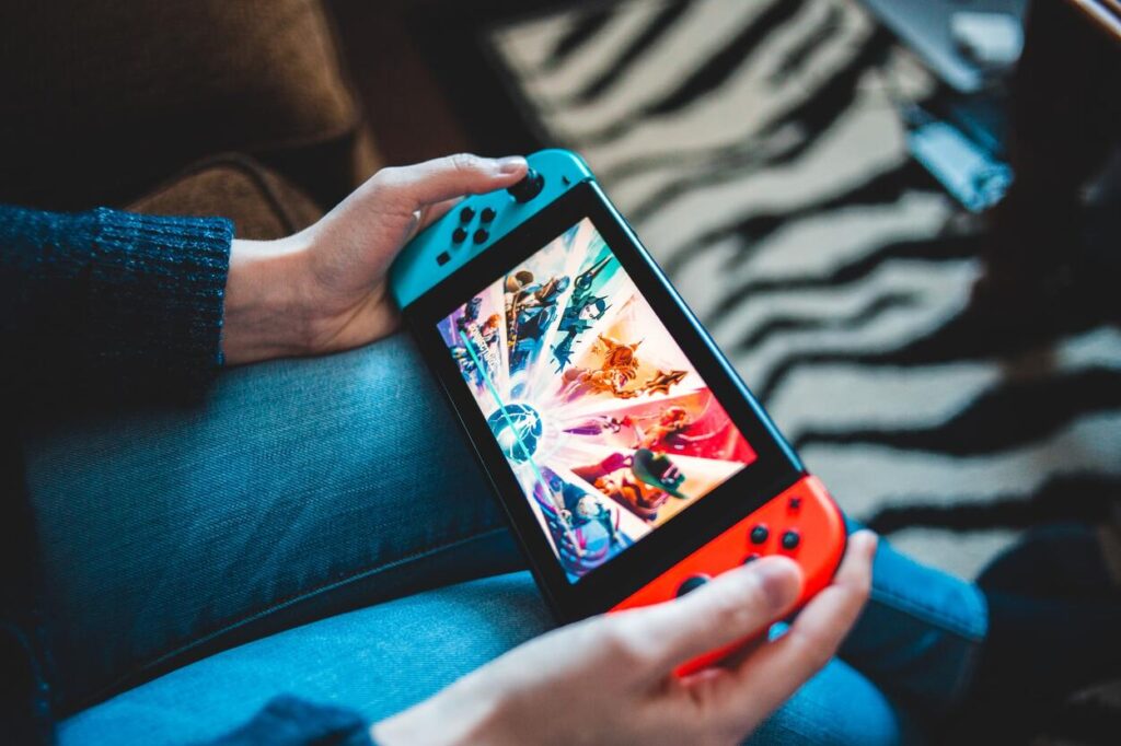Gracz korzystający z Nintendo Switch na kolanach