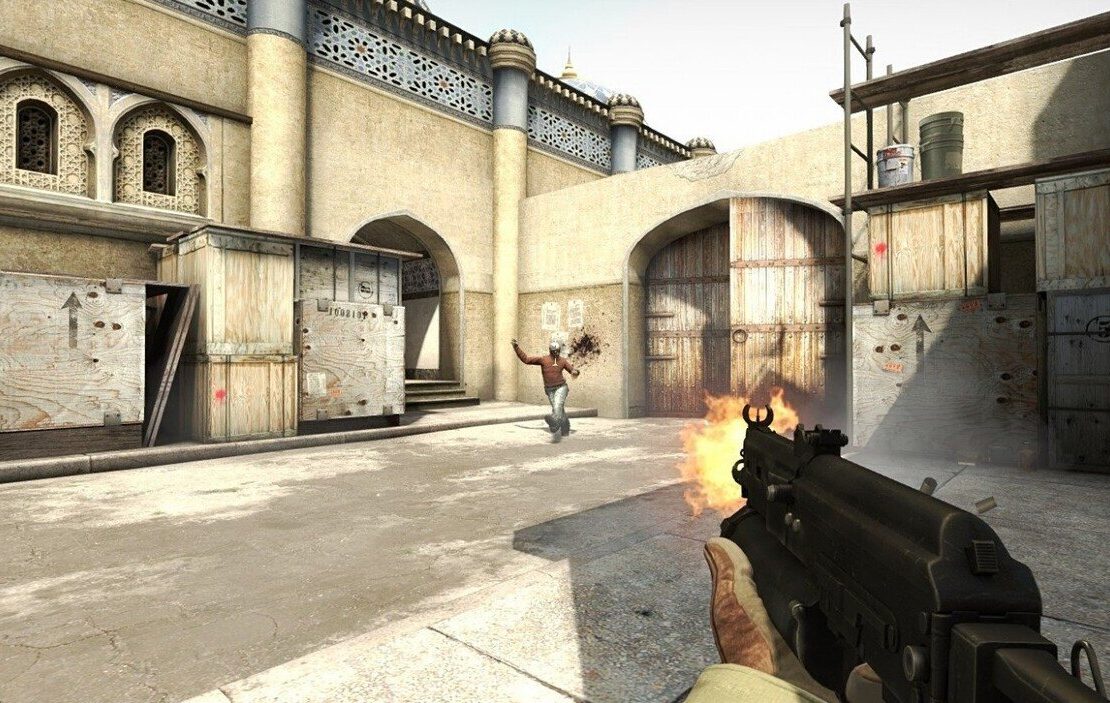 Gracz strzelający z pistoletu maszynowego do przeciwnika na pustynnej mapie w CS:GO