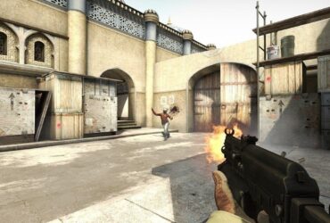 Gracz strzelający z pistoletu maszynowego do przeciwnika na pustynnej mapie w CS:GO
