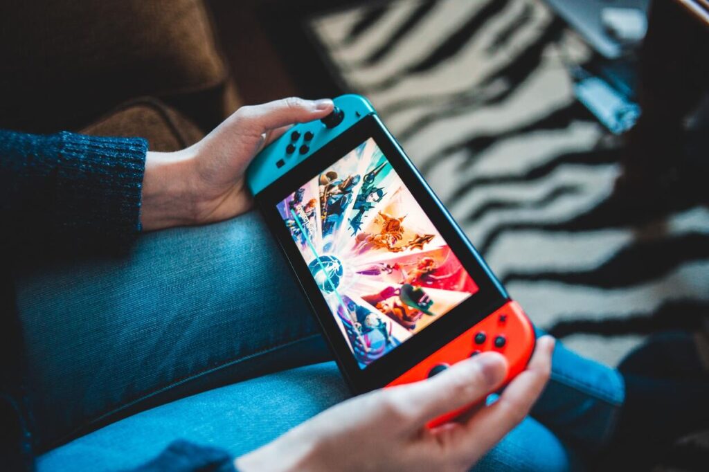 Gracz grający na Nintendo Switch siedząc na kanapie