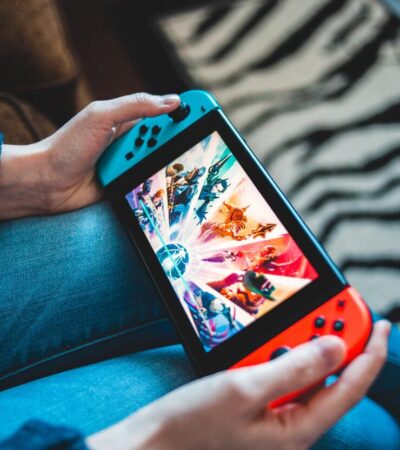 Gracz grający na Nintendo Switch siedząc na kanapie