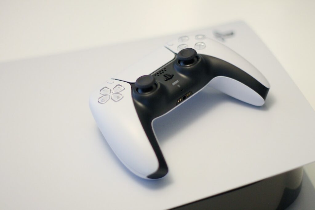 Kontroler leżący na białej konsoli Sony PlayStation 5
