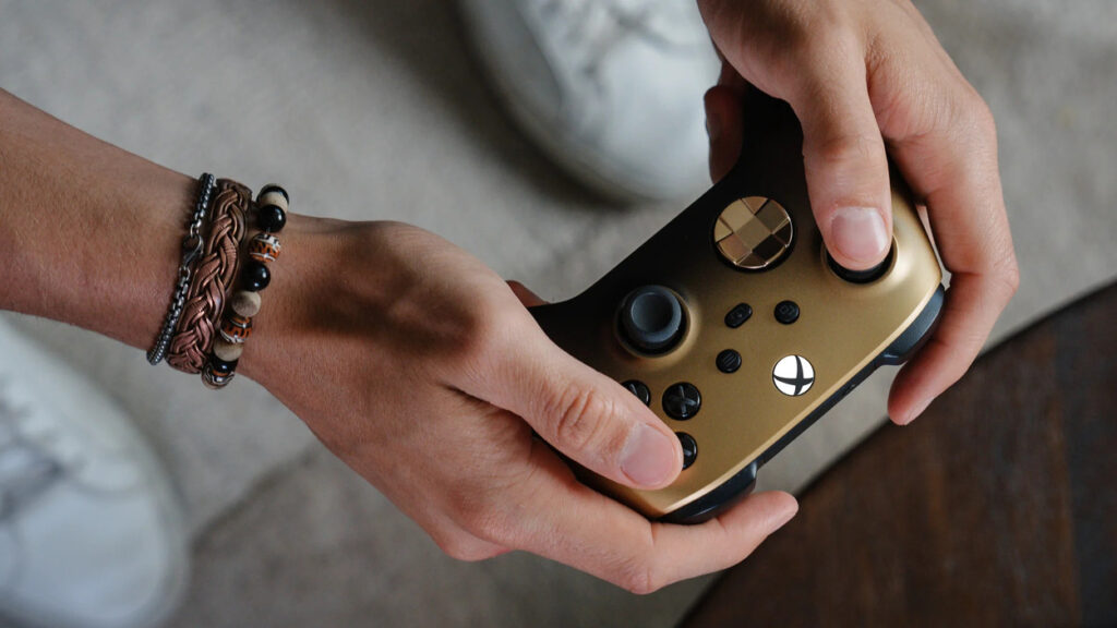 Mężczyzna trzymający kontroler Xbox Gold Shadow