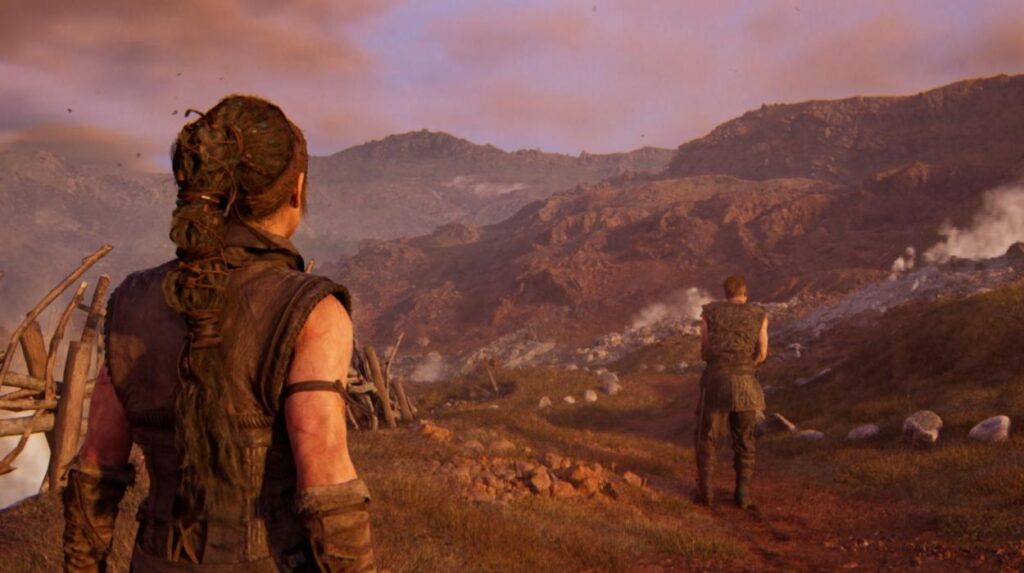 Senua z Hellblade 2 patrzy na puste pola oraz inną postać obok